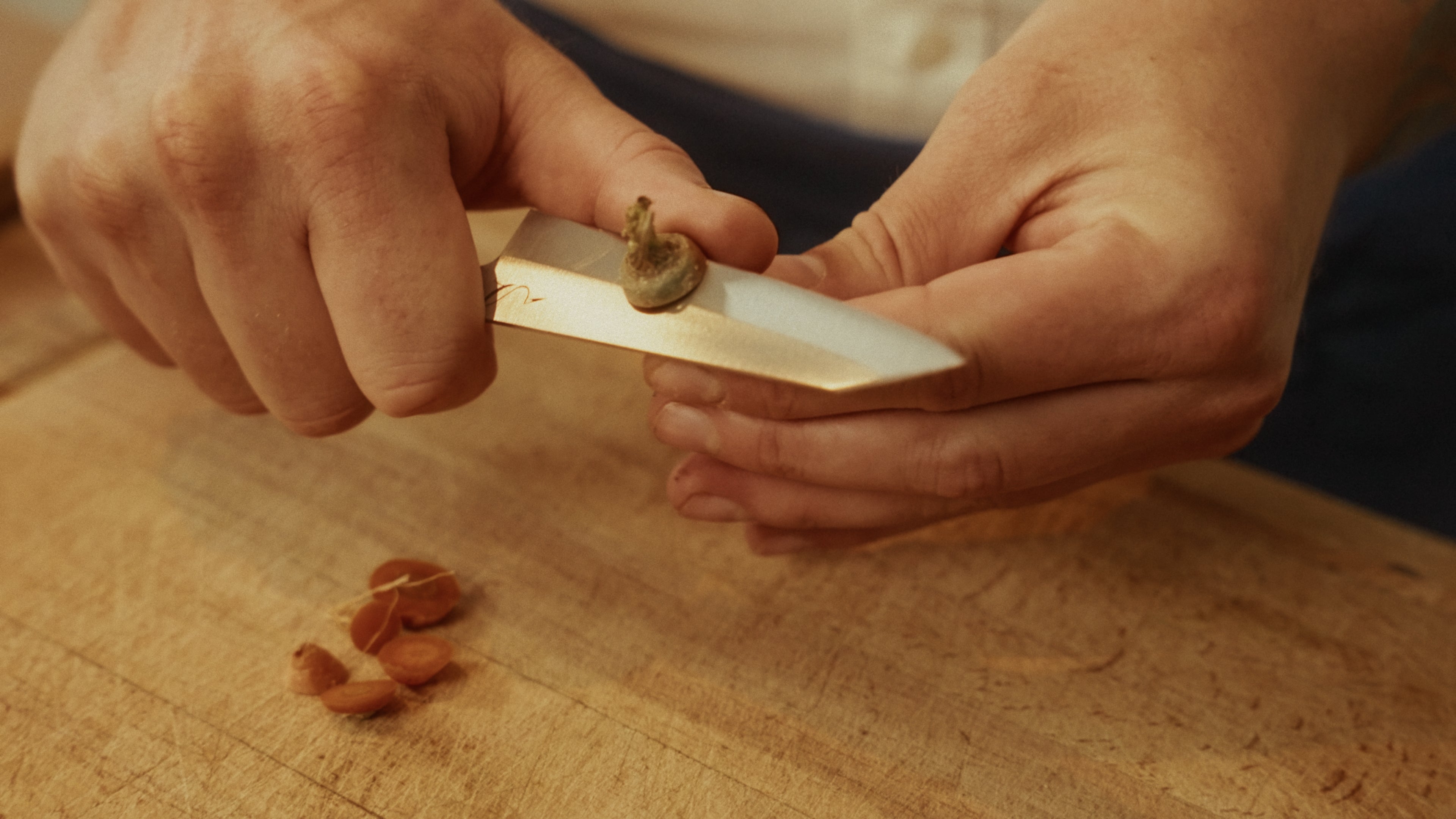 Personne coupant une carotte avec un couteau d'office 