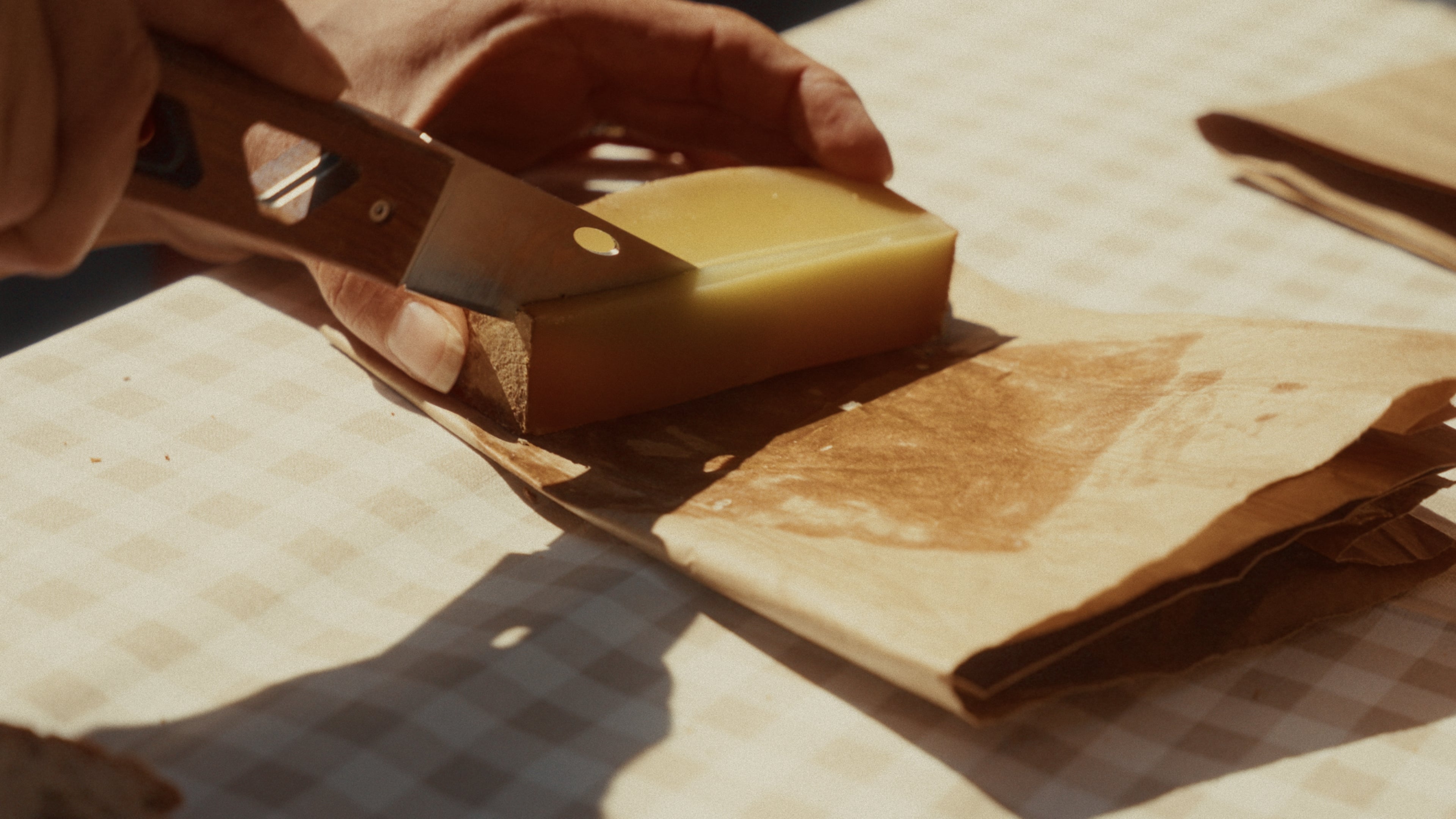 couteau pliant coupant une tranche de comté
