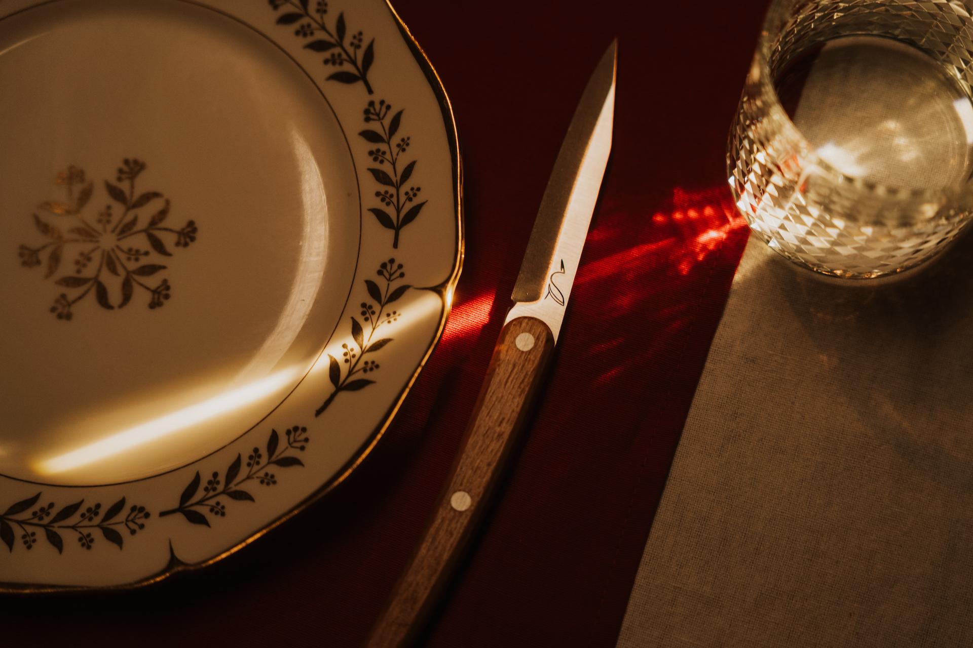 couteau de table à coté d'une assiette blanche