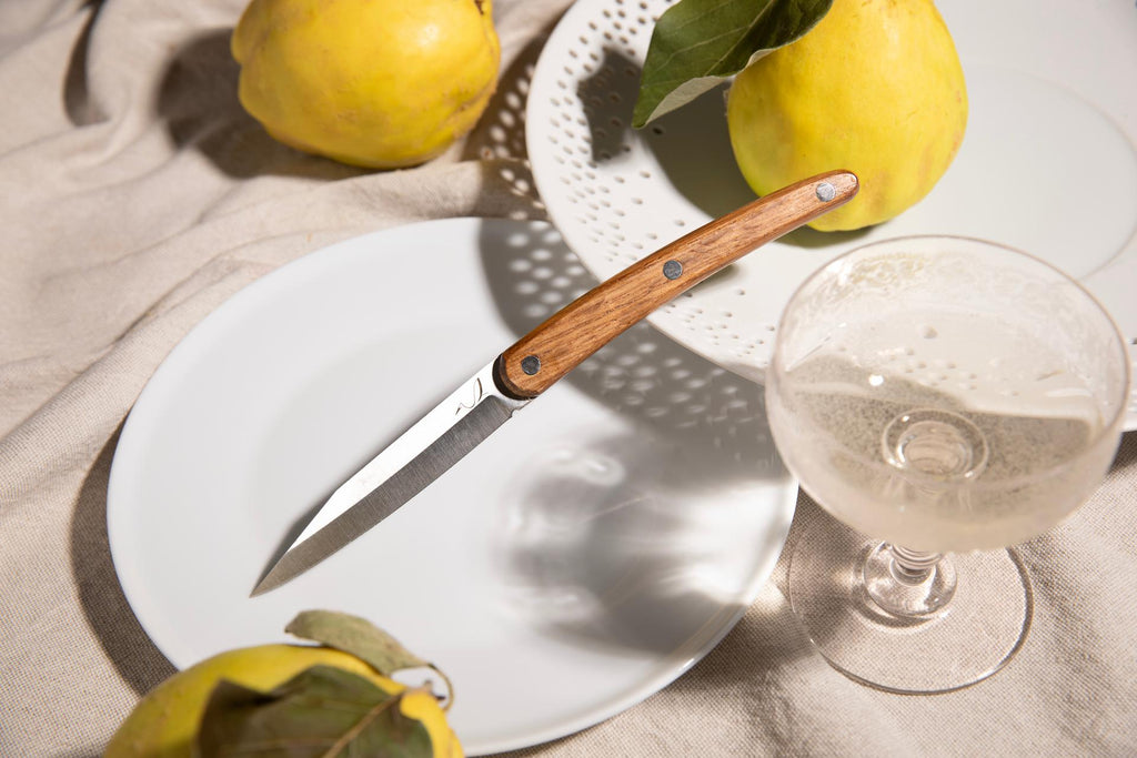 couteau de table avec manche en bois de chêne à coté de citron