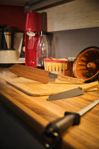 Deux couteaux de cuisine et son étui en bois sur une planche à découper 