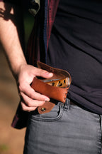 Etui en cuir brun avec son couteau pliant accroché à la taille 